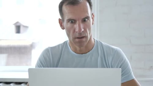 Man Reacting to Content on Laptop