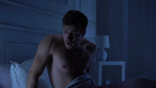 Startled Man Awakes From Nightmare in Bedroom