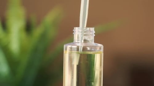 Dropper Adding Oil to Clear Glass Bottle