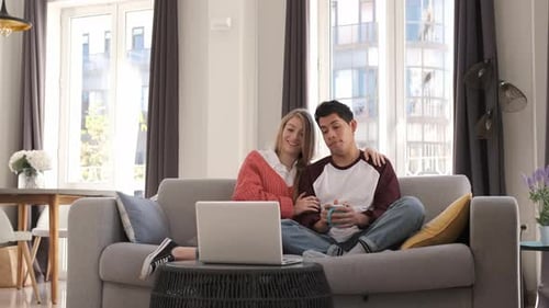 Young Couple Relaxing at Home with Laptop