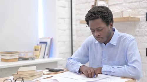 Man Reviews Financials at Office Desk