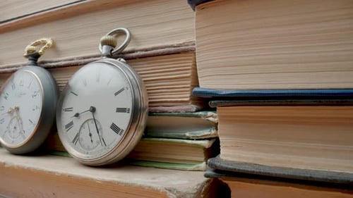 Antique Pocket Watches Resting on Stacked Aged Books
