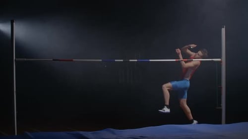 Ein männlicher Athlet rennt und springt hoch über die Latte. Zeitlupenaufnahmen des Hochsprungs