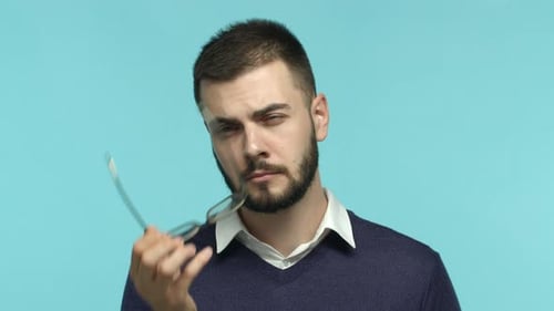 Nahaufnahme eines gutaussehenden kaukasischen bärtigen Mannes Geschäftsmann, der die Brille abnimmt und mit nachdenklichem Blick aufschaut