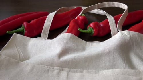 Verduras frescas orgánicas en bolsas de tela de algodón ecológico sobre mesa de madera