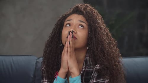 Distressed Woman Holds Hands to Face, Prays