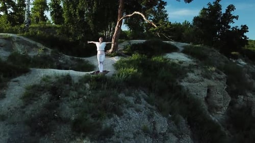 Aerial Drone View of Young Woman Practicing Yoga on Top of Rock. Lady Practicing Yoga Alone Outdoor