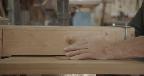 Hand Guiding Wood Through Cutting Tool