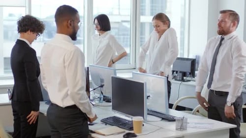 Colleagues Exercising at Desks in Office