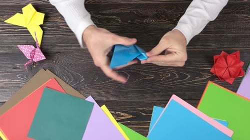Mann macht Origami-Kranich, Ansicht von oben.