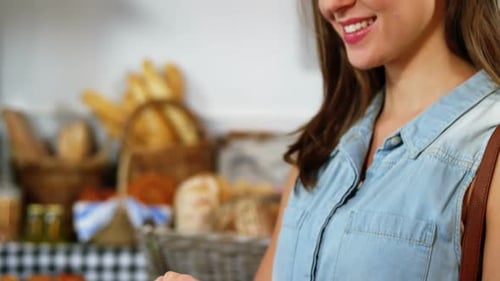 Mujer usando tableta digital en la sección de panadería
