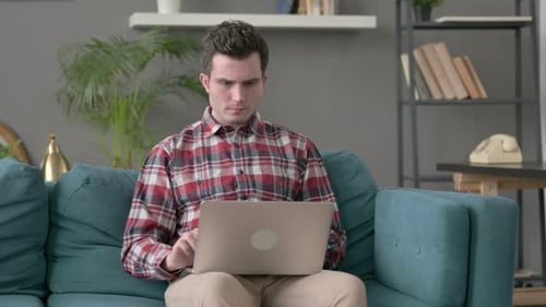 Man Reacting to Problems on Laptop Computer at Home