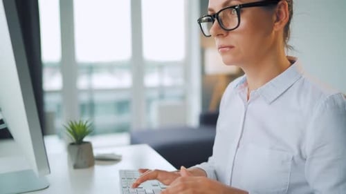 Woman Working at Computer in Bright Office