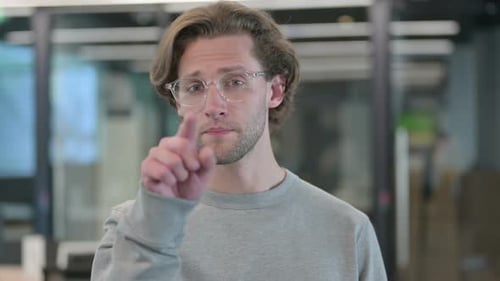 Young Man Points at Camera Indoors