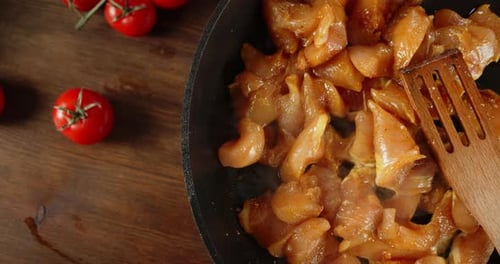 Chicken Pieces Cooking in a Pan With Tomatoes