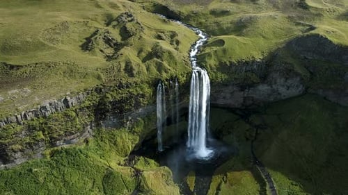 Flujo de agua del río y gran cascada en paisaje verde