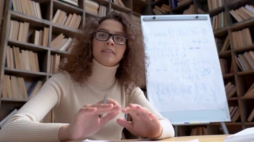 Young Hispanic School Math Teacher Looking at Webcamera Teaching Online