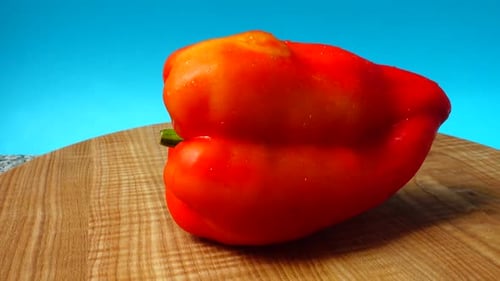 Wet Red Bell Pepper Rotating on Wooden Surface