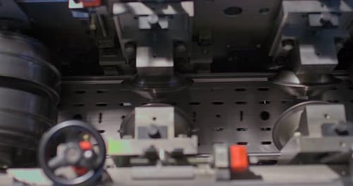 Closeup of Conveyor Belt at the Factory the Rollers are Spinning and the Metal Part is Traveling