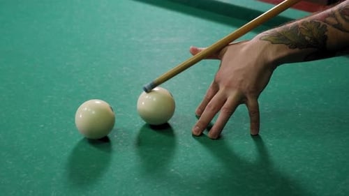 Homme jouant au billard dans un bar sombre, il frappe la balle avec une queue et frappe le trou.