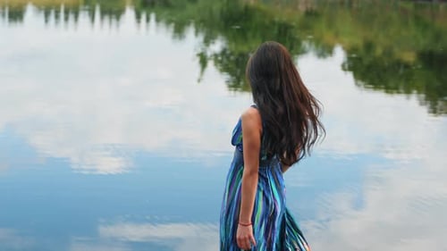Woman in Dress Twirling on Dock by Lake