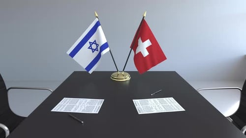 Flags of Israel and Switzerland and Papers on the Table