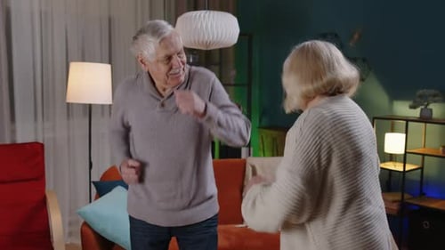 Elderly Couple Joyfully Dancing in Their Living Room