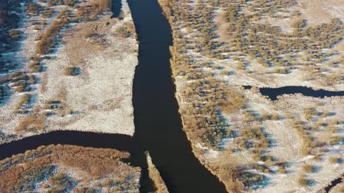 Aerial View Of Forest Woods And Partly Frozen River Landscape In Sunny Late Autunn Day