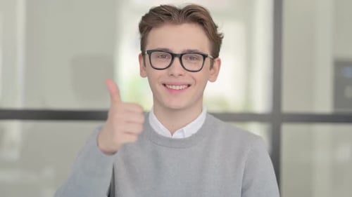 Young Man Smiles Giving Thumbs Up Gesture