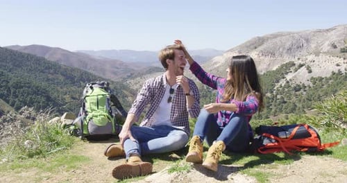 Couple Relaxing During Hike Overlooking Mountain Landscape