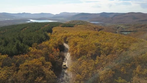 Aerial View of Car Driving Through the Forest in Mountains. Driving on Beautiful Mountain Road