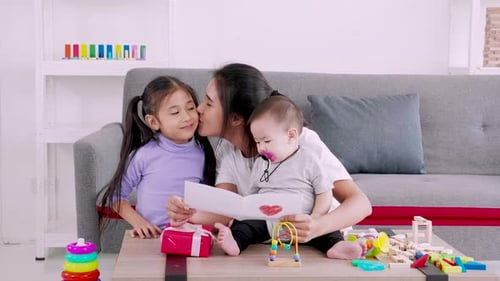 Mother Reading Handmade Card with her Two Daughters