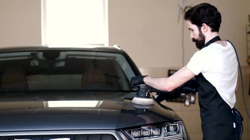 Man Polish a Car in a Garage