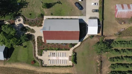 Aerial top down view of a wedding venue ceremony setup next to a barn at a farm in the countryside.