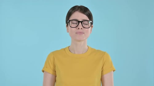 Sad Woman with Glasses Against a Blue Background