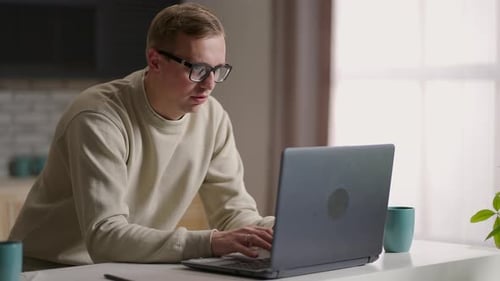 Adult Man Working on Laptop in Home Office