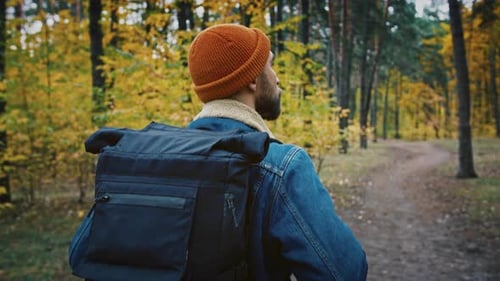 Close Up Shot of Male Backpacker Enjoying Walk in Autumn Forest Going on Trail Alone Slow Motion