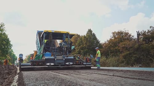 Workers with shovels laying new asphalt. Asphalt road construction.