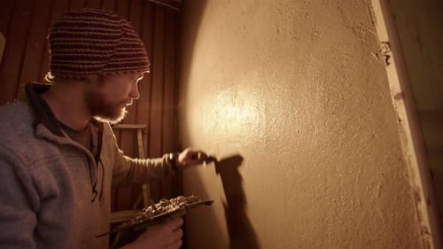 Man Smoothing Plaster on Interior Wall