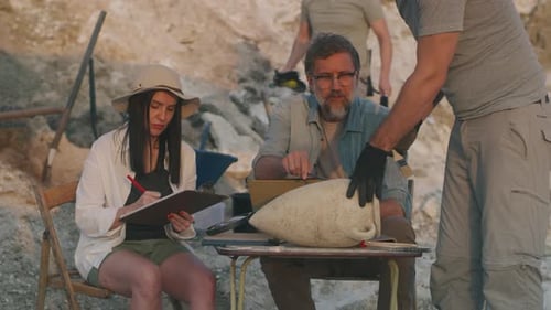 Archaeologists Examining Ancient Amphora at Excavation Site