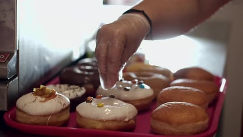 Decorating Delicious Donuts With Sprinkles In Close Up