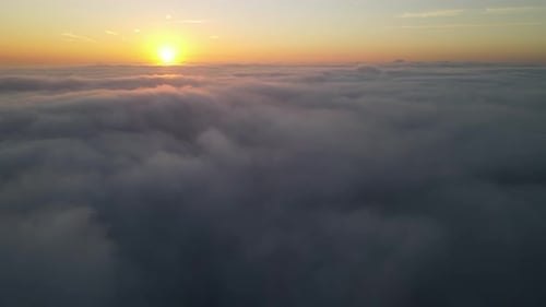 Golden Sunrise Over Ethereal Cloudscape from Above