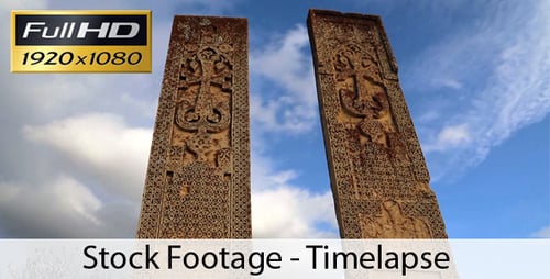 Ancient Carved Stone Pillars Under Cloudy Sky