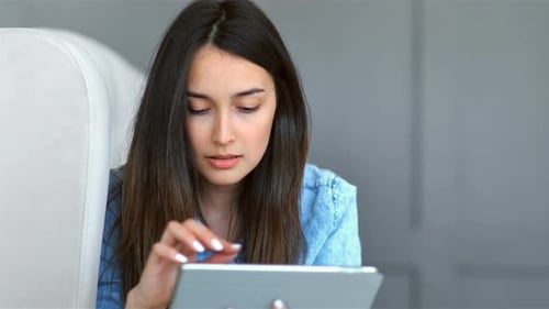 Woman Using a Tablet While Sitting