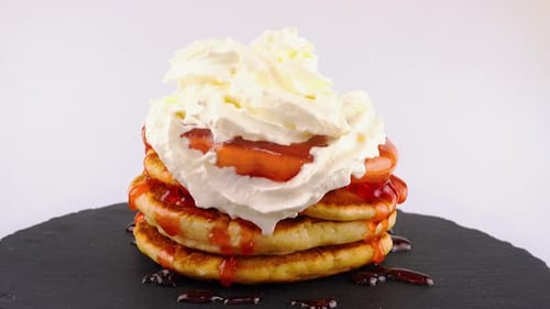 Pancakes Stacked High with Cream and Strawberry Sauce