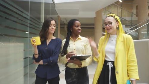 Three Women Walking and Talking in Office Building