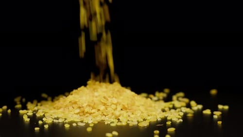 Bulgur Grains Pouring onto a Black Surface