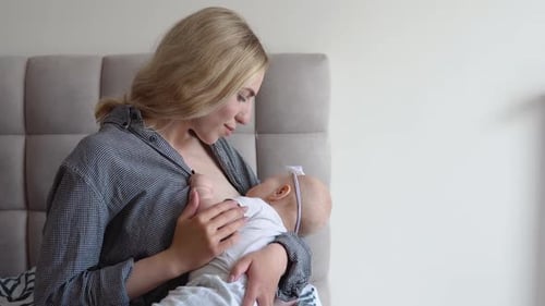 Mother Breastfeeding Newborn Baby at Home