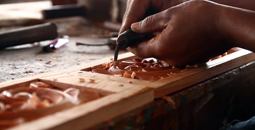 Craftsman Carefully Carving Wood in the Workshop