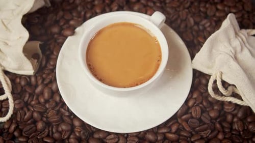 Cup of Delicious Warm and Aromatic Coffee Surrounded By Roasted Seeds